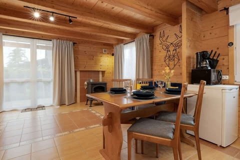A closer view of the dining area featuring a wooden table set complementing the cabin’s natural interior.