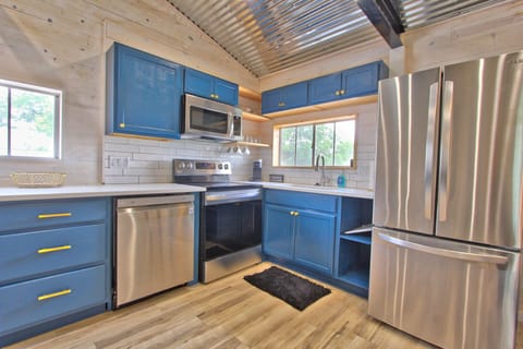 Closer view of kitchen with dishwasher, range/over, microwave, and refrigerator.