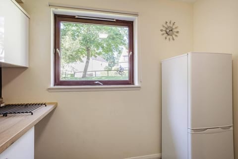 Kitchen with window for ventilation and large fridge freezer