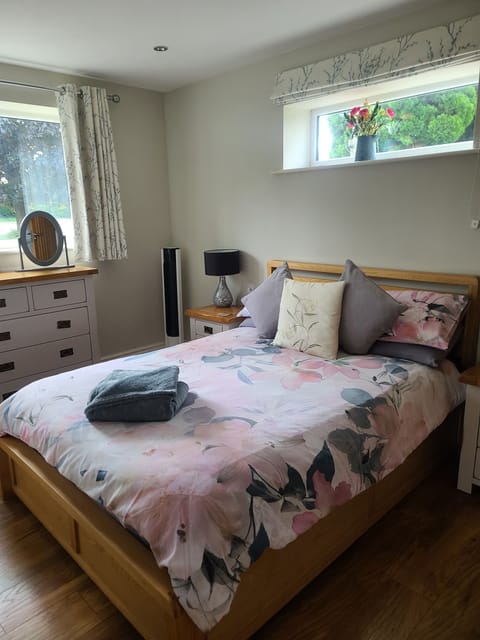 Cosy double bed with chest of drawers, wardrobe, full length mirror, portable fan, bedside tables and lamps, dimmer switch for spotlights.