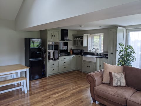 Other half of the open plan room showing the edge of the dining nook, the kitchen and the edge of the living space.