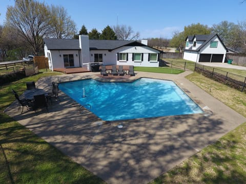 Pool with basketball, putting green, grill and outdoor bar with fridge.

