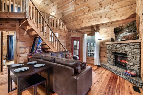 Open layout with fireplace, dining table and loft stairs