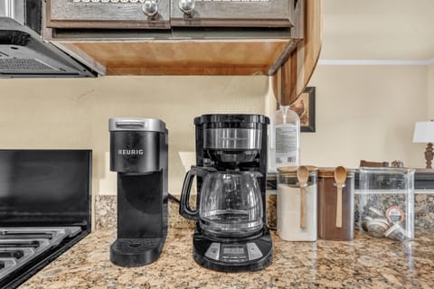 A K-cup and drip coffee maker with coffee, pods, and sugar