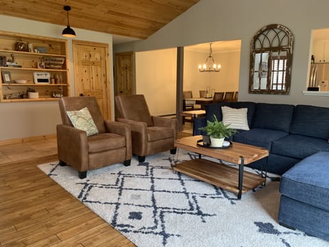 Spacious living room with vaulted ceilings, cozy furniture, fireplace, and view