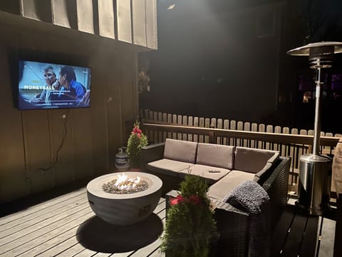Relax outside watching TV keeping warm by the fire pit 
