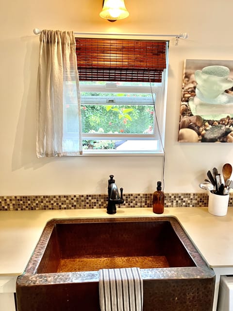Hammered copper farm sink with private courtyard views.