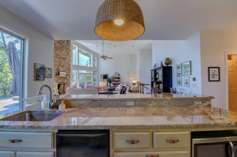 Kitchen island with ice maker and microwave opens to vaulted living and dining.