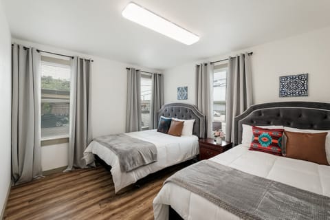 Bright and Cozy Bedroom with Two Double Beds, Fresh Linens, and Plush Pillows