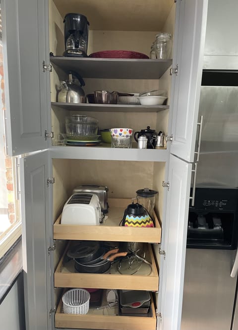 Pantry with toasters, teapot, blender, mixing bowls, pots and pans