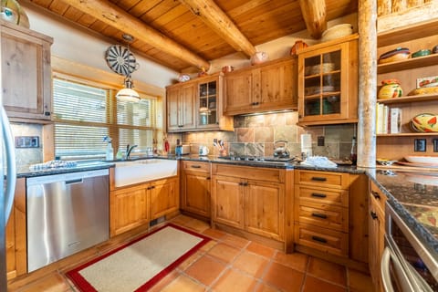 Kitchen with ample granite countertops, a farmhouse sink, and stainless steel appliances