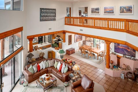 Cozy living room with rustic wooden beams and leather armchairs, offering a warm and inviting atmosphere.