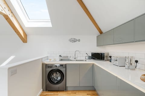 Cedar House, St Agnes. First floor: Fully-equipped kitchen with an electric oven and hob, microwave, dishwasher, fridge/freezer and washing machine