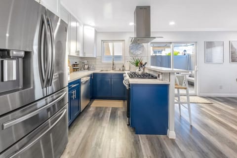 Open concept kitchen, island, dining room opens to side patio w/ fire pit