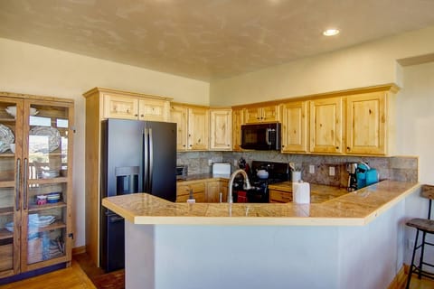 Whip up your favorite meals in the fully stocked kitchen, complete with modern appliances, rustic touches, and a cozy breakfast bar for casual dining.