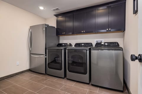Laundry room with full size wash, 2 full size dryers and and extra fridge/freezer