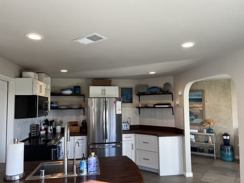 Well-stocked kitchen with sink at peninsula and breakfast bar seating for two.