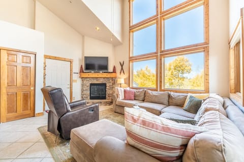 Spacious living area with vaulted ceilings, gas fireplace, flat screen TV and awesome views and great light thanks to the huge windows.
