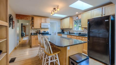 Spacious, sunny kitchen with skylights and granite bar.