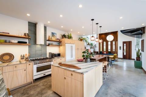 Fridge, oven, sink, drawers, oepn space, table, chairs, living room view