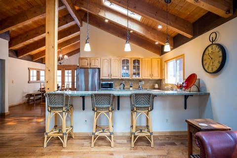 The spacious living room and kitchen are seamlessly connected, offering a bar seating area that's perfect for mixing drinks or casual meals