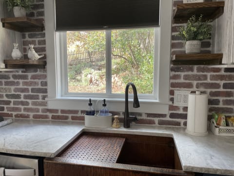 Kitchen window looks out on private backyard with calming water feature