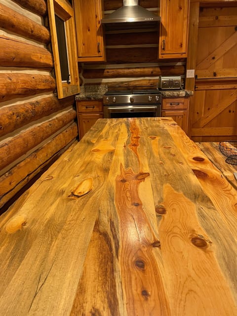 Long kitchen table and Kitchen Aid gas cooking range.