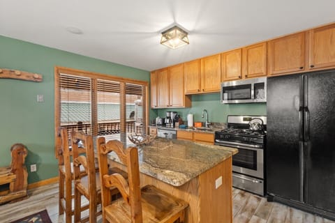 Kitchen with Island Bar - Open floor plan kitchen with island bar seating, gas range, spacious refrigerator and drip coffee maker.