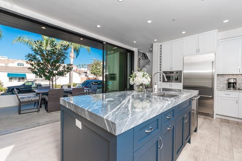 Sliding doors open from the kitchen, extending the dining area to the outdoors. (Outdoor dining table seats 6).