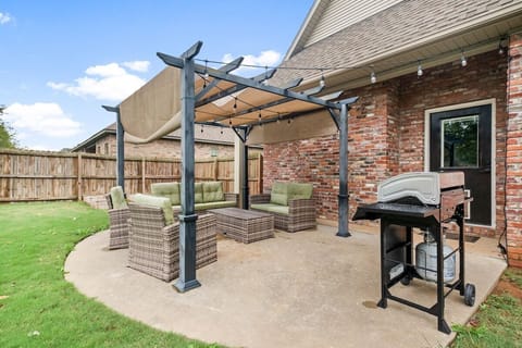 Our fenced in yard features outdoor seating, overhead string lights, a BBQ grill, and kid's swing set.