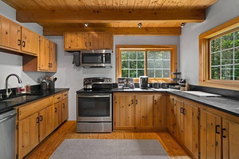 Beautiful kitchen with stainless steel stove, refrigerator, dishwasher, and awesome black soap stone counter tops.