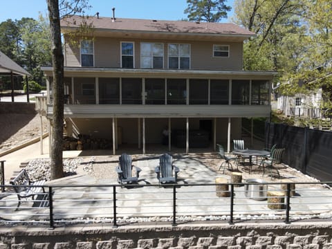 View looking from lake of home, patio and screened in porch.