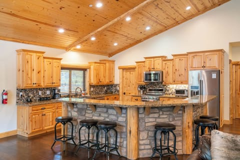 Kitchen features a large island, breakfast bar and modern appliances.