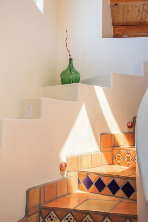 Spiral stairs leading to upstairs loft, 2 guest rooms, and rooftop patio