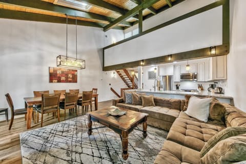 Large living room with vaulted ceilings, light coming in through the sky lights. Section sofa with lots of room around the coffee table.