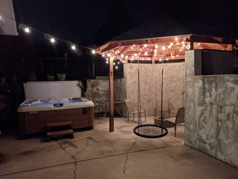 Backyard gathering area with private hot tub, propane fire put and mood lighting