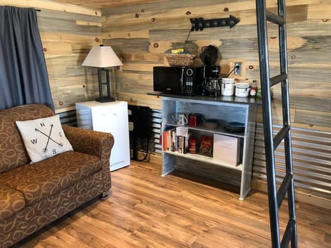 Den features a small couch with a pull-out full-size bed inside.