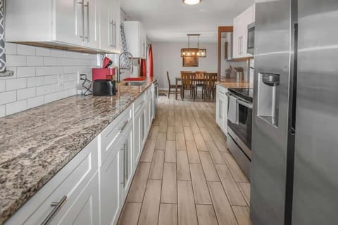 Sleek and modern kitchen featuring elegant granite countertops, stylish white cabinetry, and stainless steel appliances—perfect for cooking and entertaining