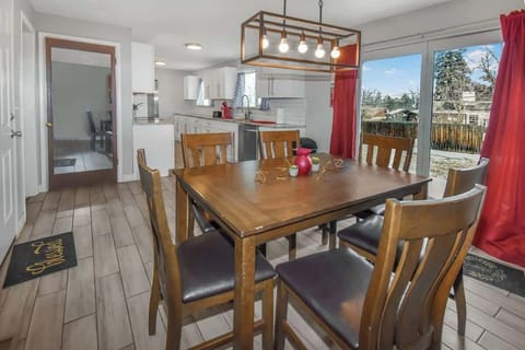 Cozy and inviting dining area with warm wooden furniture, modern lighting, and a bright view of the backyard—perfect for family meals and gatherings!