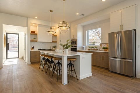 In this view of the kitchen you can see the large island with seating for 5, the 5 burner gas cooktop, the wall mounted over and microwave as well as the large prep area beneath the window.