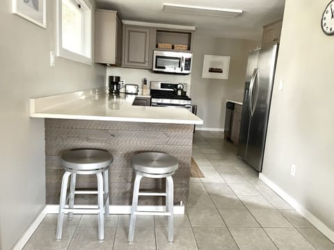 Kitchen with gas stove, quartz counters and everything you would need to cook.