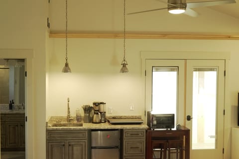 2 burner range; convection oven; mini-fridge; deep-well sink; ceiling fan.