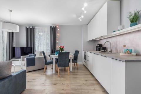  The spacious living area is combined with a kitchenette with white cabinets that hold all the necessary accessories.