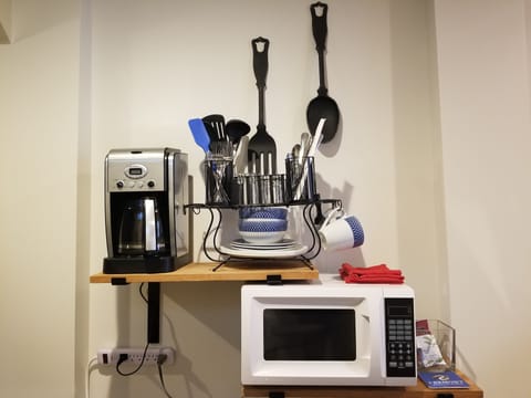 View of coffee maker, microwave and dishes & utensils