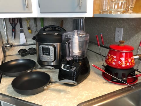 stocked with pans, blender, knives, scissors, and a fondue set.