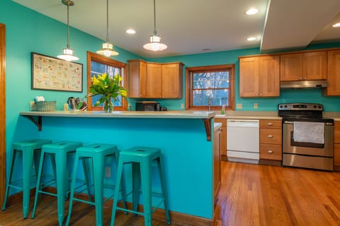 A fully equipped kitchen with a central island and stools, facilitating meal preparation and casual dining experiences.