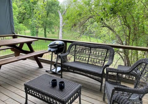 Large rear deck with electric bbq pit, picnic table and comfortable seating.