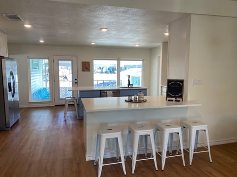 Looking from family room into kitchen - 10 barstools.
