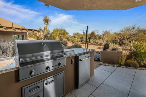 Outdoor kitchen with ample seating area.