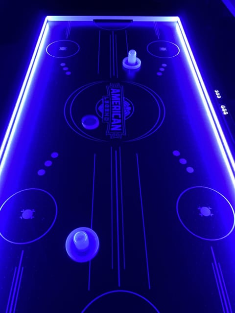 The air hockey table lights up and keeps score while you play.